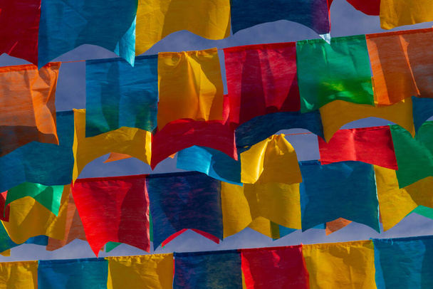 Varios tendederos con banderas de tela contra el cielo azul para la fiesta de junio - típico festival brasileño. "Cuadrilha". - Foto, Imagen