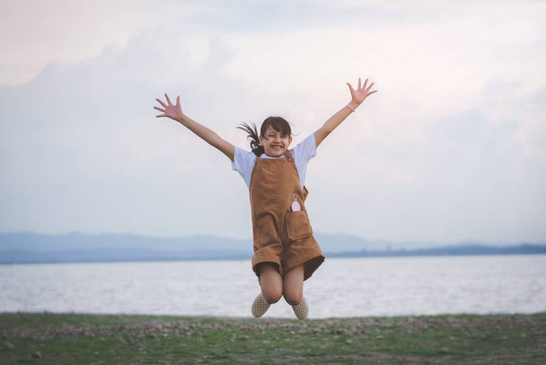 Счастливая девочка прыгнула на пляж во время летних каникул - Фото, изображение