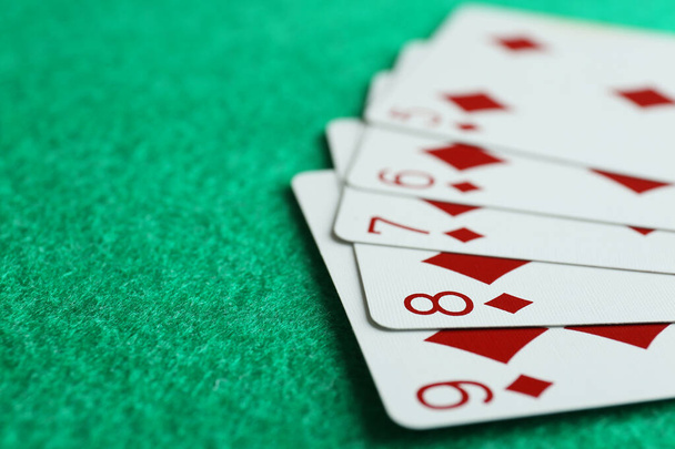 Playing cards with straight flush combination on green table, closeup. Space for text - Fotografie, Obrázek