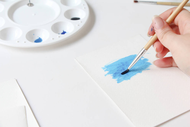 Fechar a mão de mulher com o desenho de escova no bloco de notas. processo de criação de aquarela pintura, hobby, amor próprio. - Foto, Imagem