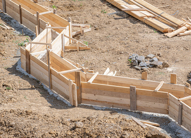 Drewniana deska do wylewania betonowych fundamentów domu. Budowa fundamentów. - Zdjęcie, obraz
