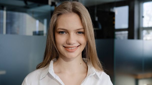 Close-up portrait caucasian happy satisfied confident female student smiling toothy smile successful pretty woman model posing indoors looking at camera young joyful businesswoman standing in office - Foto, imagen