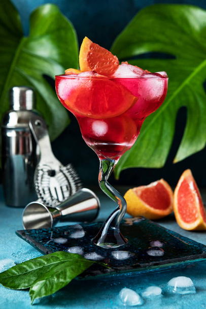 Martini  cocktail with red  grapefruit with tonic and ice  in glass on  colorful background - Photo, image