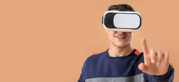 Joven con gafas de realidad virtual sobre fondo beige con espacio para texto - Foto, imagen