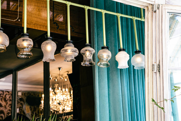 Antique vintage chandeliers with lamps inside hang in a row, retro exterior detail. - Fotó, kép