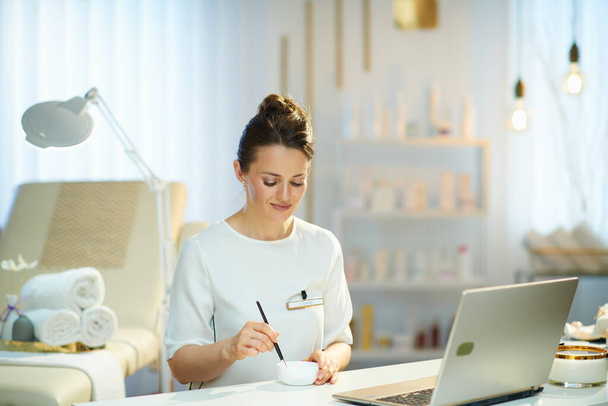 female worker with laptop working in modern beauty studio. - Fotó, kép