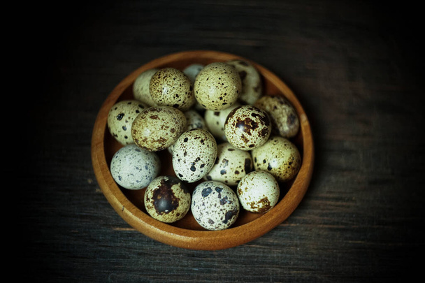 Fresh quail eggs close up on a wooden table small hard boiled eggs rustic top view - Fotoğraf, Görsel