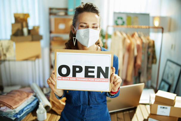 stylish 40 years old small business owner woman with ffp2 mask and open after covid sign in the office. - Photo, image