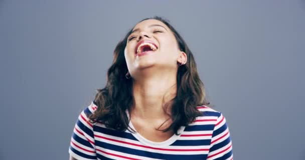4k video footage of a young woman laughing against a grey background. - Video