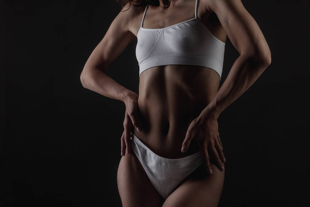 body shape of a sporty fitness girl studio photo on a dark background, the concept of sports and healthy eating - Fotografie, Obrázek