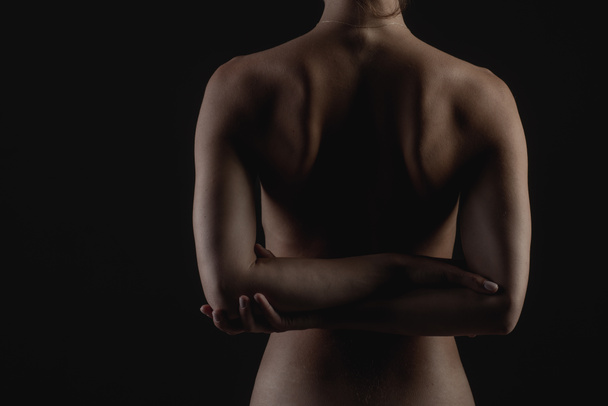 espalda de niña primer plano sobre un fondo oscuro, el concepto de tratamiento de la columna vertebral y la espalda - Foto, imagen