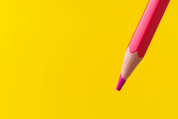 Kolorowe zbliżenie ołówka z selektywnym naciskiem na rysik i rozmazane żółte tło. Kopiuj miejsce na tekst. - Zdjęcie, obraz