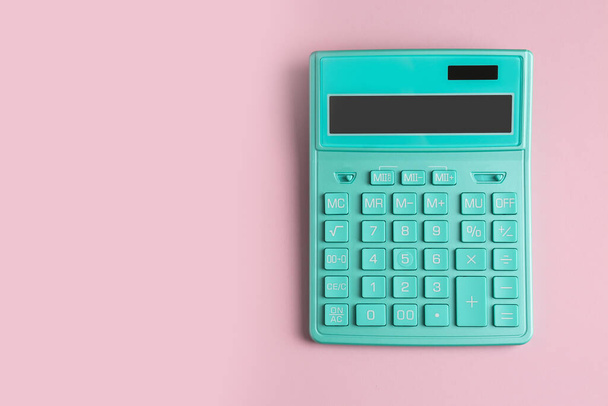 Turquoise calculator on pink background, top view. Space for text - Fotó, kép