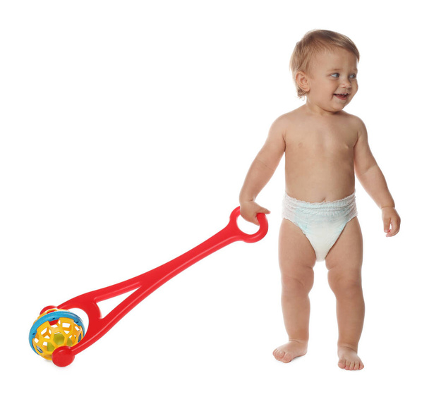 Cute baby with push toy learning to walk on white background - Фото, зображення