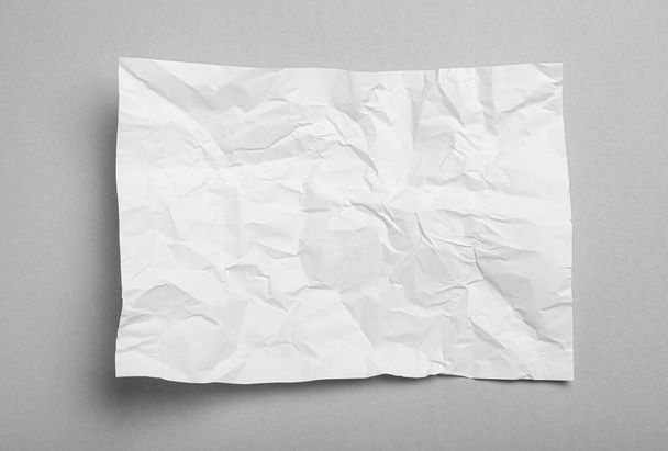 Sheet of white crumpled paper on grey background, top view - Фото, зображення