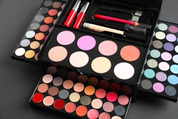 Large makeup case with different decorative cosmetics on dark background - Foto, Bild