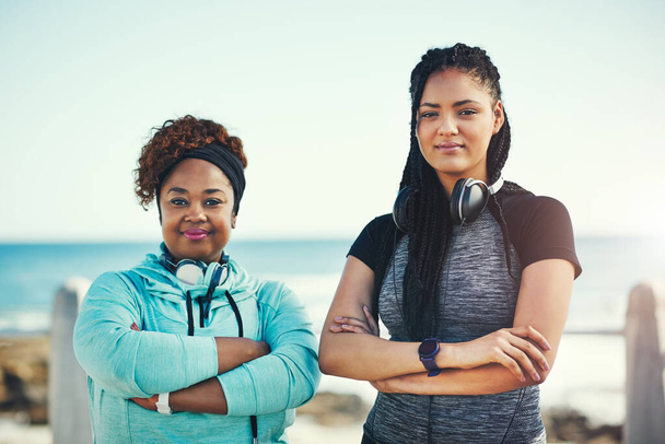 Portrait of two sporty young women standing on the promenade. - Photo, image