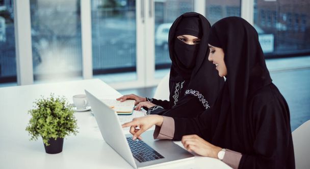 two young arabic businesswomen working on a laptop in their office. - Valokuva, kuva