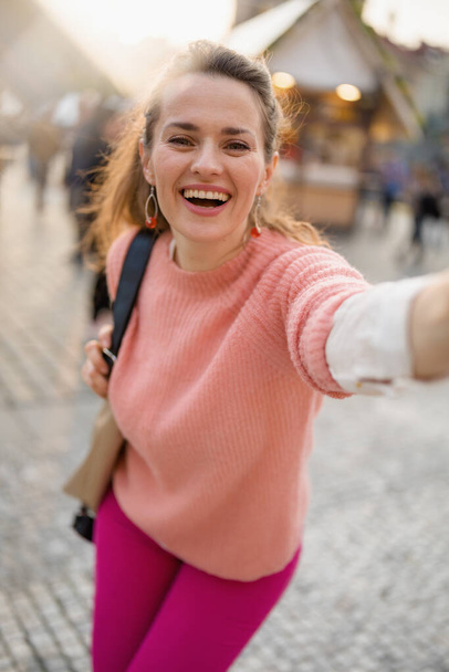 happy modern 40 years old woman at the fair in the city taking selfie. - Φωτογραφία, εικόνα