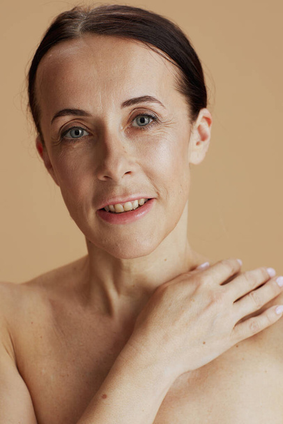 Portrait of modern woman posing on beige background.  - Foto, afbeelding