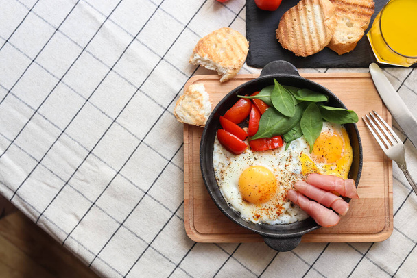 Delicious fried eggs with spinach, tomatoes and ham served on table, flat lay. Space for text - Foto, imagen