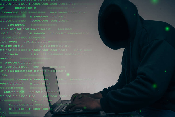 A hacker fekete kapucnis pulcsit viselt. Hatalmas pénzügyi adatok ellopása a számítógépeken bináris kód digitális interfész és sok csökkenő dollár és fekszik az asztalon.Hacking és malware koncepció. - Fotó, kép