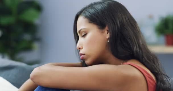 4k video footage of a beautiful young woman looking upset and resting her head on her arms at home. - Felvétel, videó
