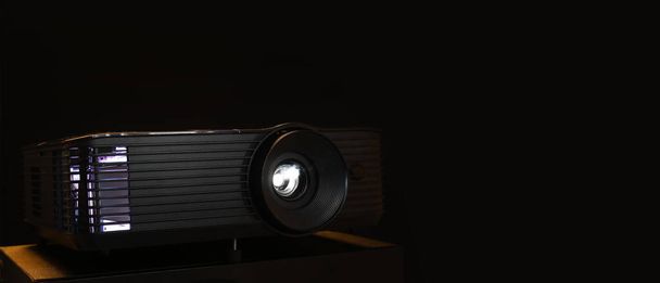 Video projector on black background with space for text - Foto, afbeelding