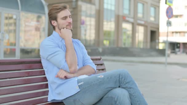 Cansado hombre de mediana edad durmiendo sentado al aire libre en el banco - Metraje, vídeo