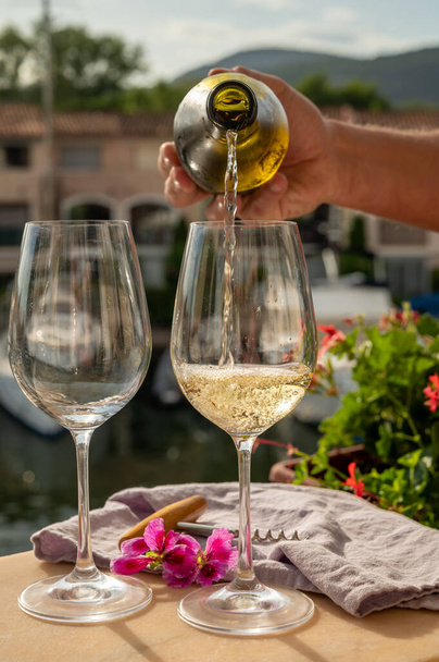 Verter en copas de vino blanco frío en el puerto deportivo de Port Grimaud, vacaciones de verano en la Riviera francesa en Provenza, Francia - Foto, imagen