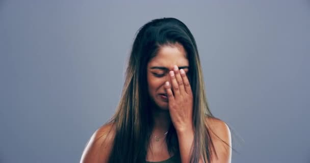 4k video footage of a young woman crying against a grey background. - Кадры, видео