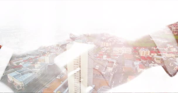 4k video footage of two unrecognizable businesspeople shaking hands superimposed with a modern cityscape. - Πλάνα, βίντεο