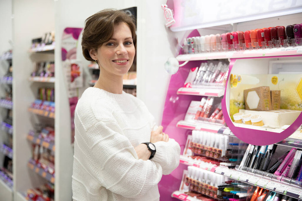 giovane donna compra cosmetici negozio di specialità. - Foto, immagini