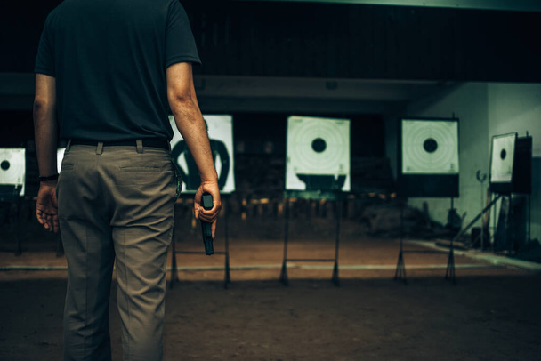Professionals carry a 9mm pistol inside a shooting range. - Foto, imagen