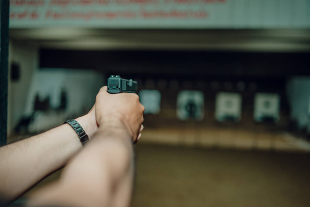 Professionals practice shooting a 9mm pistol inside a shooting range. - Fotoğraf, Görsel