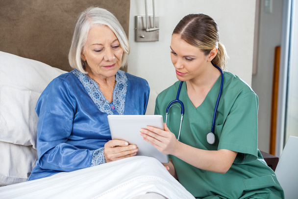 Female Nurse And Senior Woman Using Tablet PC - Фото, зображення