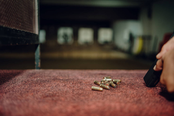 Professionals practice shooting a 9mm pistol inside a shooting range. - Photo, Image