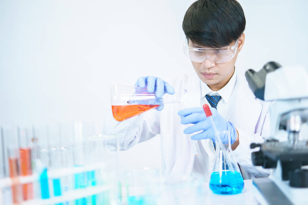 Азіатські вчені серйозно вивчають хімічний склад у лабораторії. Спеціалізація в юній біотехнології Використовуйте сучасне обладнання для мікроскопів. - Фото, зображення