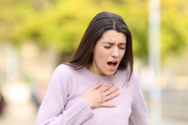 Stressed teen having breath problems standing in a park - Φωτογραφία, εικόνα