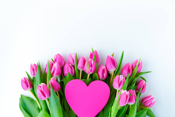 Primavera flat lay com coração rosa valentine e tulipas isoladas no fundo branco. - Foto, Imagem