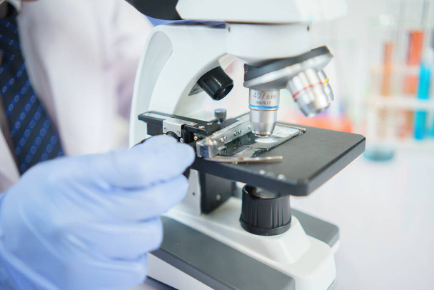 Asian scientists are seriously studying the chemical composition in the laboratory. Specializing in Young Biotechnology Use advanced microscope equipment. - Photo, Image