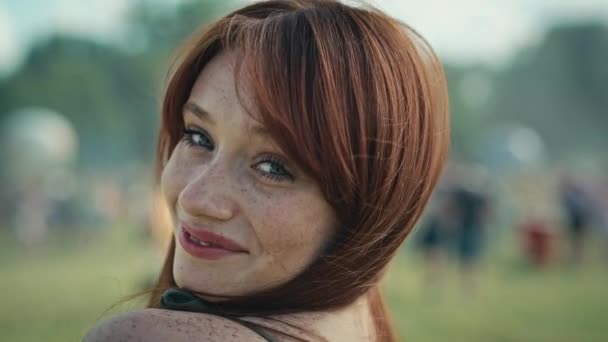 Portrait de jeune femme caucasienne souriante aux cheveux roux au festival de musique. Tourné avec caméra hélium rouge en 8K.  - Séquence, vidéo