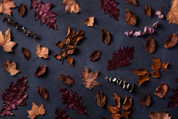 Herbst-Erntedank-Komposition mit dekorativen getrockneten Blättern. Flache Lage, Blick von oben, Stillleben saisonaler Hintergrund für Grußkarte, Kopierraum - Foto, Bild