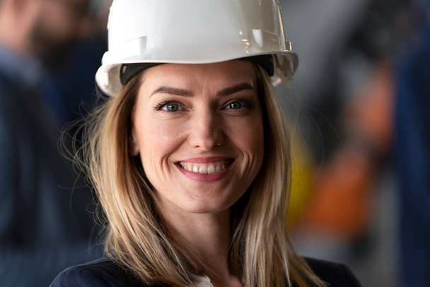 A portrait of female chief engineer in modern industrial factory looking at camera. - Photo, Image