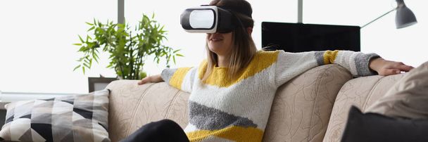 Portrait of female sit on couch wear vr glasses modern device at home and enjoy spare time. Visual effects, fun leisure. Innovation, entertainment concept - Foto, imagen