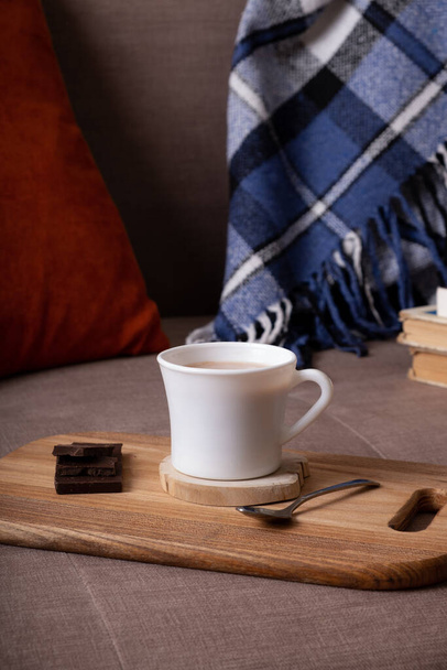 Autumn mood background with cup of cocoa, plaid and books on sofa. Hot drink in autumn concept. - Φωτογραφία, εικόνα
