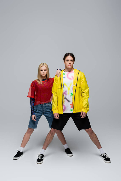 Fashionable couple in sneakers posing on grey background - Foto, afbeelding