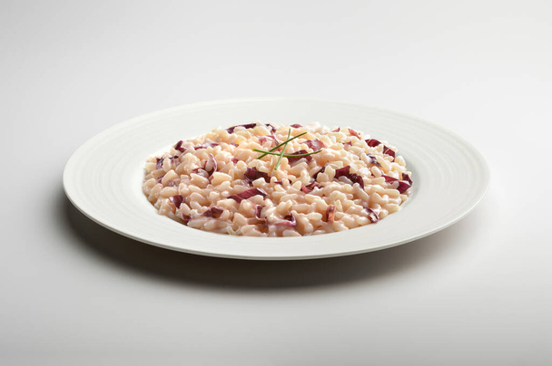 Prato de jantar branco com risoto com Treviso radicchio vermelho e cebolinha isolada sobre fundo branco - Foto, Imagem
