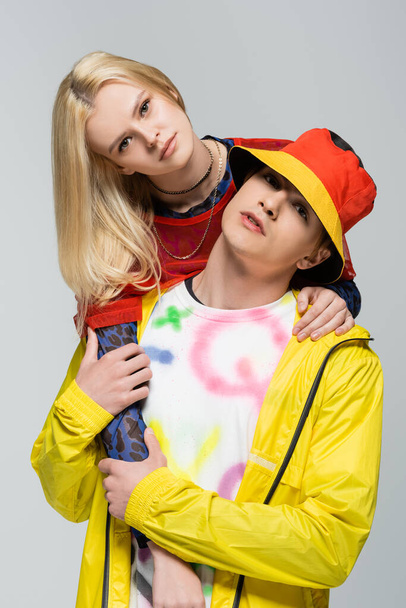 Portrait of stylish couple in bright clothes looking at camera isolated on grey  - Fotografie, Obrázek