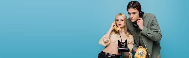 Stylish models talking on telephones on blue background, banner  - Photo, Image